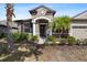 Inviting front entrance with stone accents, a decorative wreath, and well-maintained landscaping at 7911 Hampton Lake Dr, Tampa, FL 33647