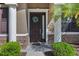 Close-up of the elegant front door with sidelight, decorative wreath, and stone accents at 7911 Hampton Lake Dr, Tampa, FL 33647