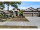 Charming single-story home with a three-car garage and beautifully landscaped front yard with stone accents at 7911 Hampton Lake Dr, Tampa, FL 33647