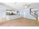 Open-concept living area showcases tile flooring, neutral paint, kitchen bar, and stairwell access at 7911 Hampton Lake Dr, Tampa, FL 33647