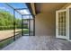 View of the screened patio with tile flooring and an open doorway leading to the home's interior at 7911 Hampton Lake Dr, Tampa, FL 33647
