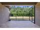This bright screened patio offers a view of the green grass and trees in the yard at 7911 Hampton Lake Dr, Tampa, FL 33647