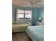 Cozy bedroom featuring two beds, a large window, and calming turquoise walls at 7951 58Th N Ave # 308, St Petersburg, FL 33709