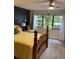 Comfortable bedroom features an oak bed frame, a ceiling fan and natural light through the windows at 7951 58Th N Ave # 308, St Petersburg, FL 33709