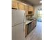 Galley kitchen featuring stainless steel sink, light wood cabinets, granite countertops, and wood-look flooring at 7951 58Th N Ave # 308, St Petersburg, FL 33709
