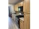 Galley kitchen featuring light wood cabinets, granite countertops, stainless steel appliances, and wood-look flooring at 7951 58Th N Ave # 308, St Petersburg, FL 33709