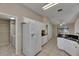 Kitchen with tile floor, white cabinets, white refrigerator, and black countertops at 812 Amethyst Way, Valrico, FL 33594