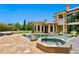 Backyard featuring a pool, spa, and stone patio, with mature landscaping and a playset in the background at 1102 Merry Water Dr, Lutz, FL 33548