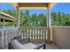 Balcony with stone columns and balusters overlooking lush green trees under a clear blue sky at 1102 Merry Water Dr, Lutz, FL 33548