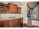 Elegant bar area featuring wood cabinetry, granite countertops, and a window with scenic views at 1102 Merry Water Dr, Lutz, FL 33548