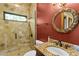 Red bathroom with a glass shower, granite countertop, and round mirror with ornate frame at 1102 Merry Water Dr, Lutz, FL 33548