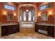 Spa-like bathroom featuring a soaking tub, dual vanities, and arched windows at 1102 Merry Water Dr, Lutz, FL 33548
