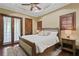 Comfortable bedroom with hardwood floors, tray ceiling, ceiling fan, and a king-size bed at 1102 Merry Water Dr, Lutz, FL 33548