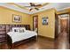 Bedroom featuring hardwood floors, tray ceiling, a storage headboard, and adjacent bathroom at 1102 Merry Water Dr, Lutz, FL 33548