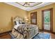 Bedroom with hardwood floors, stylish queen-sized bed, and balcony access through French doors at 1102 Merry Water Dr, Lutz, FL 33548