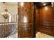 Interior view of elevator and staircase with custom woodwork, metal railings, and chandelier at 1102 Merry Water Dr, Lutz, FL 33548