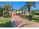 Beautiful home exterior featuring lush landscaping, brick driveway, and a charming facade at 1102 Merry Water Dr, Lutz, FL 33548