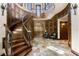 Grand foyer with a curved staircase, detailed woodwork, and stone flooring at 1102 Merry Water Dr, Lutz, FL 33548