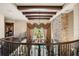Second-floor view of the foyer with decorative chandelier, stone accent wall, and pool view at 1102 Merry Water Dr, Lutz, FL 33548