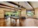 Entertaining game room with pool table, exposed beams, and an adjacent outdoor patio overlooking lush scenery at 1102 Merry Water Dr, Lutz, FL 33548