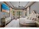 Bright main bedroom with a decorative tray ceiling, hardwood floors, and views of the outdoor living space at 1102 Merry Water Dr, Lutz, FL 33548