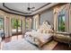 Luxurious main bedroom with tray ceilings, hardwood floors, and views of the outdoor living space at 1102 Merry Water Dr, Lutz, FL 33548