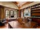 Executive home office with custom wood paneling, built-in shelving, and arched windows at 1102 Merry Water Dr, Lutz, FL 33548
