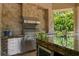 Outdoor kitchen with stainless steel appliances, granite countertops, and a stone backsplash, perfect for entertaining at 1102 Merry Water Dr, Lutz, FL 33548