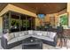 Relaxing outdoor living area with a stone fireplace, built-in grill, bar seating, and comfortable lounge furniture at 1102 Merry Water Dr, Lutz, FL 33548