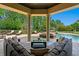 Spacious outdoor seating area with a large sectional sofa, coffee table, and views of the pool and surrounding landscape at 1102 Merry Water Dr, Lutz, FL 33548