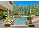 Luxury pool area with water features, in-ground hot tub, and ample seating surrounded by lush greenery at 1102 Merry Water Dr, Lutz, FL 33548