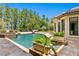 Beautiful swimming pool with travertine tile surround and fountain features, lush landscaping, and tiled planters at 1102 Merry Water Dr, Lutz, FL 33548
