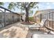 Paver patio features mature tree, lounge chairs, and a screened-in pool, offering a relaxing outdoor space at 11318 Stoneybrook Path, Port Richey, FL 34668