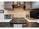 Close-up of the range in the kitchen with stainless steel appliances and a mosaic backsplash at 11318 Stoneybrook Path, Port Richey, FL 34668