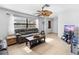 Bright living room featuring a large window, tiled flooring, and a ceiling fan at 11318 Stoneybrook Path, Port Richey, FL 34668
