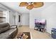 Comfortable living room with tiled flooring, a ceiling fan, and a modern entertainment center at 11318 Stoneybrook Path, Port Richey, FL 34668