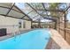 Sparkling swimming pool with a screened-in enclosure and a patio area, ideal for relaxation and entertainment at 11318 Stoneybrook Path, Port Richey, FL 34668