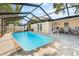 Outdoor swimming pool features a screened-in enclosure, a paved patio, and easy access to the house at 11318 Stoneybrook Path, Port Richey, FL 34668