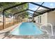 Outdoor swimming pool features a screened-in enclosure and a paved patio area perfect for relaxation at 11318 Stoneybrook Path, Port Richey, FL 34668