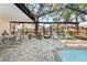 Relaxing screened-in pool area with clear blue water, outdoor seating, and a well-maintained patio at 11318 Stoneybrook Path, Port Richey, FL 34668