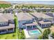 Backyard aerial view of the blue home featuring a pool with safety fence, covered patio and lush landscaping at 11416 Alachua Creek Ln, Riverview, FL 33579
