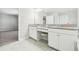 Bright bathroom featuring double vanities, granite countertops and white cabinetry at 11416 Alachua Creek Ln, Riverview, FL 33579