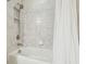 Bathroom featuring a shower head, white tub and tile surround with a shower curtain at 11416 Alachua Creek Ln, Riverview, FL 33579