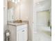 Bathroom vanity with granite countertop, white cabinetry and doorway leading to bedroom at 11416 Alachua Creek Ln, Riverview, FL 33579