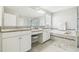 Bright bathroom featuring double vanities, granite countertops and white cabinetry at 11416 Alachua Creek Ln, Riverview, FL 33579