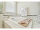 Bright bathroom featuring soaking tub with decorative tile surround and granite countertops at 11416 Alachua Creek Ln, Riverview, FL 33579