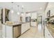 Modern kitchen with stainless appliances, granite counters, and a center island with pendant lighting at 11416 Alachua Creek Ln, Riverview, FL 33579