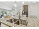 Granite kitchen island features a stainless sink and views into the home's living areas at 11416 Alachua Creek Ln, Riverview, FL 33579