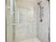 Close-up of modern shower with glass door, a rainfall showerhead, and tiled walls at 11416 Alachua Creek Ln, Riverview, FL 33579