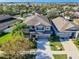 Aerial view of a suburban home with a large driveway, well-manicured lawn, and mature trees at 11525 Scarlet Ibis Pl, Riverview, FL 33569